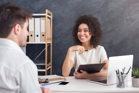 African-american female employer interviewing man in office