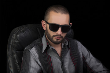 Obraz premium Portrait of serious handsome men in sunglasses over black bacground.