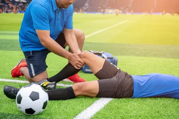 Tuinposter Footballer wearing a blue shirt, black pants injured in the lawn during the race. © mnirat