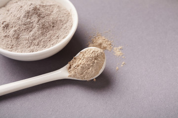 Preparing natural cosmetic white mud mask on background