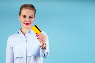 bank employee woman holding golden credit card blue studio portrait.