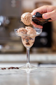 Man Serving Chocolate Ice Cream Into The Glass