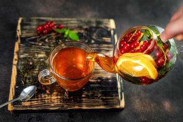 Pouring herbal hot tea in glass cup