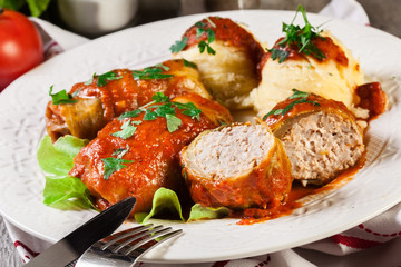 Stuffed cabbage with meat and rice served with boiled potatoes and tomato sauce