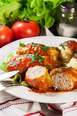 Stuffed cabbage with meat and rice served with boiled potatoes and tomato sauce