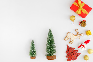 Christmas composition.  Christmas tree, gold balls, snowman, reindeer, pine cone and  gift boxes on white background. Creative flat lay, border and copy space