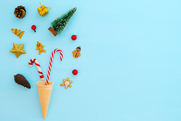 Christmas composition.  Ice cream cone with Christmas decoration on blue background. Creative flat lay, border and copy space