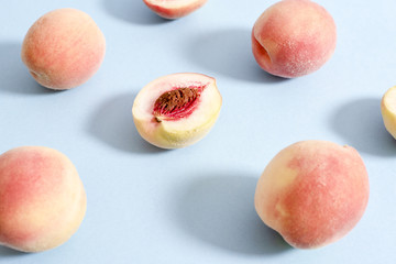 Whole ripe beautiful peaches and one split in half with putamen