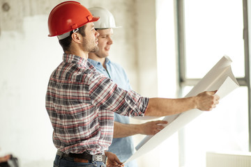 the chief of builders is leading with working process of his colleagues at work. side view photo