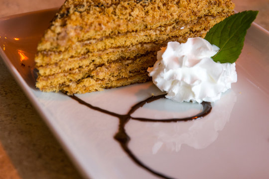 delicious marlenka cake served with cream whipped cream on a decorated plate