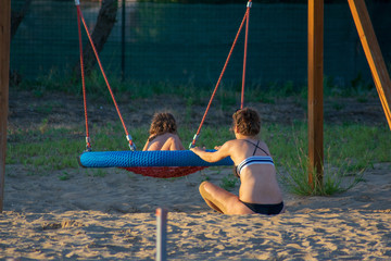View of a mother and her daughter spending time on the playing ground 