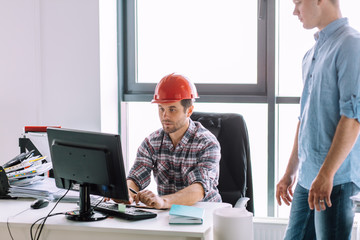 serious handsome engineer is working with computer indoors. computer engineering concept