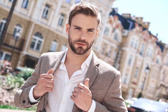 Handsome elegant young man in urban setting in European city, walking