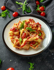 Spinach ricotta Ravioli in tomato sauce with wild rocket and parmesan cheese