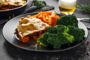 Traditional English beef beer, ale pie served with carrots and broccoli