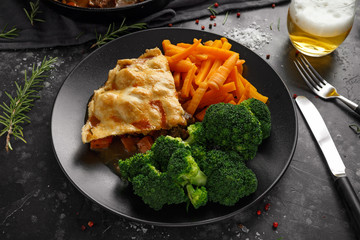 Traditional English beef beer, ale pie served with carrots and broccoli