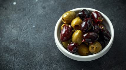 Black, Green Olives with herbs in white bowls
