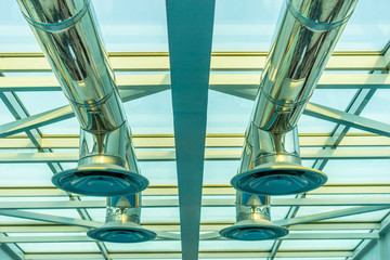 Fototapeta na wymiar Ventilation on the ceiling. Chromed pipes for air ventilation. Glass ceiling.