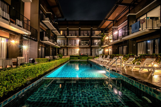 long exposure night shot image of poolside resort building with swimming pool and pool chairs along pool side at Lalune beach resort Samed island Rayong Thailand