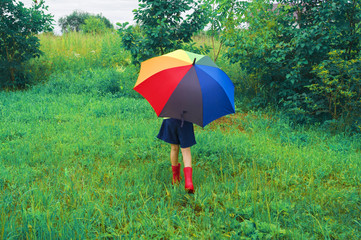 The child walks with a rainbow umbrella