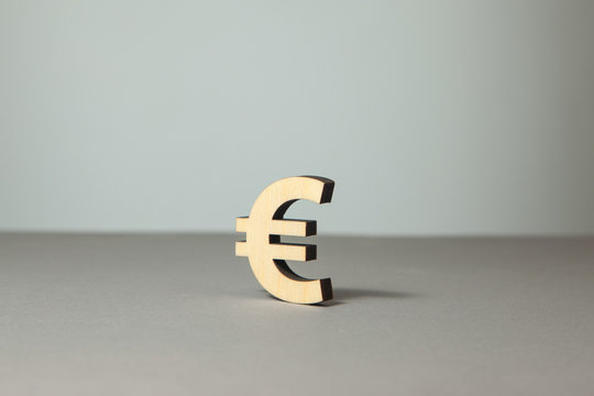 Euro symbol from wood on a gray background