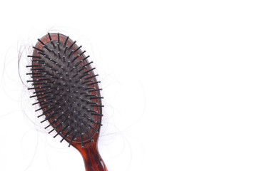 Black comb with long loss woman hair on white background for head healthcare problem. Hair fall after combing in hairbrush..National Alopecia Awareness Month