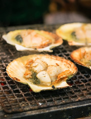 Delicious grilled scallop street food at Kuromon Ichiba Market, Osaka