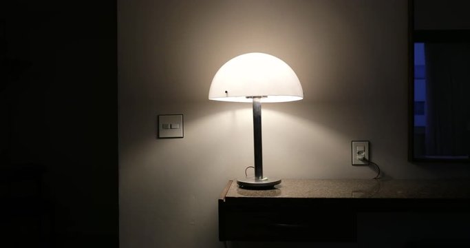 Man turning lamp light ON when arriving home