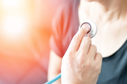 Doctor hand with stethoscope check up elderly woman people. Old aging female seeing medical physician in clinical healthcare hospital.