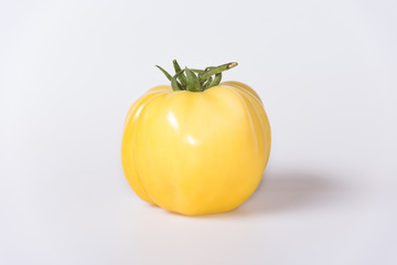 yellow single tomato on white background