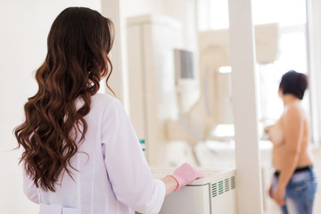 Back view of the young excellent breast specialist who is carrying up the ultrasound examination of...