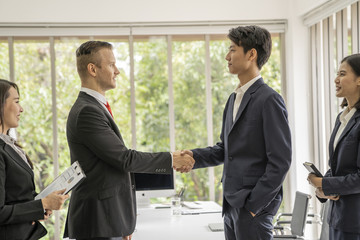 Young business man shaking hands during meeting in office. Success,dealing,greeting ,busisess partner concept.