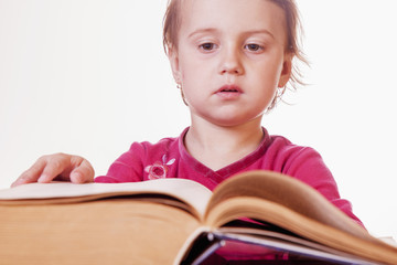 Little cute child girl watching a book (Science, education, knowledge, self-improvement, success)