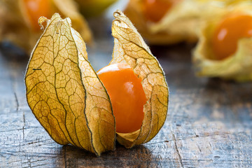 Physalis fruit (Physalis Peruviana) with husk on wooden background - closeup