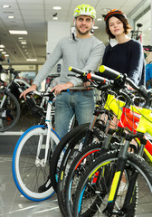 Fototapeta na wymiar female and male in helmet standing with bicycle