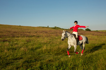 The horsewoman on a red horse. Horse riding. Horse racing. Rider on a horse.