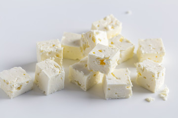 Feta cheese diced cubes stacked on white background - Close up image