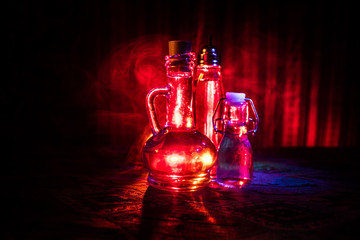 Antique and vintage glass bottle on dark foggy background with light. Poison or magic liquid...