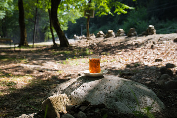 Eastern black tea in glass on a eastern carpet. Eastern tea concept. Armudu traditional cup. Sunset background. Selective focus