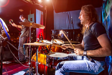 Fototapeta na wymiar Drummer playing on drum set on stage.