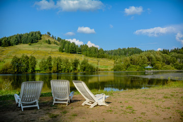 Fototapeta premium loungers by the lake next to the hill