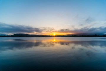 View of the sun setting over a lake in the Scottish Highlands.