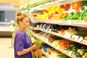 Middle-age woman buying vegetables at the market