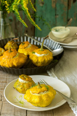 Pattypan squash or pumpkins stuffed with ricotta with basil and dill and served with sour cream sauce. Vegetarian food.