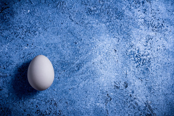 Happy Easter. Top view whole white eggs on rustic blue background. Copy space for text