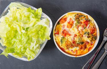 french quiche lorraine with salad in small white bowls