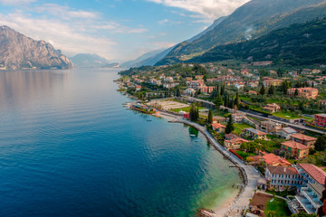 View of lake Garda from the tower in the town of Malcesine. Italy. A view of the tiled roofs of the Italian city. Lake Garda. Riva del Garda. - obrazy, fototapety, plakaty
