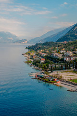 View of lake Garda from the tower in the town of Malcesine. Italy. A view of the tiled roofs of the Italian city. Lake Garda. Riva del Garda.