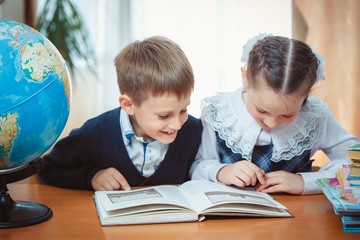 Schoolboy and schoolgirl with a globe