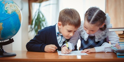 Schoolboy and schoolgirl with a globe